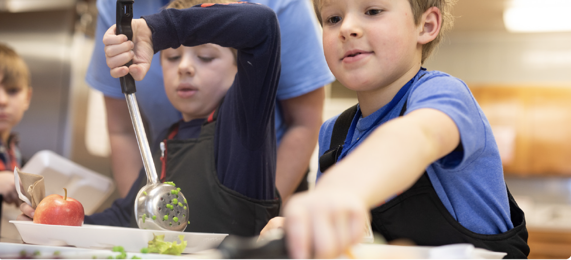 Kids serve themselves in the school lunch line.